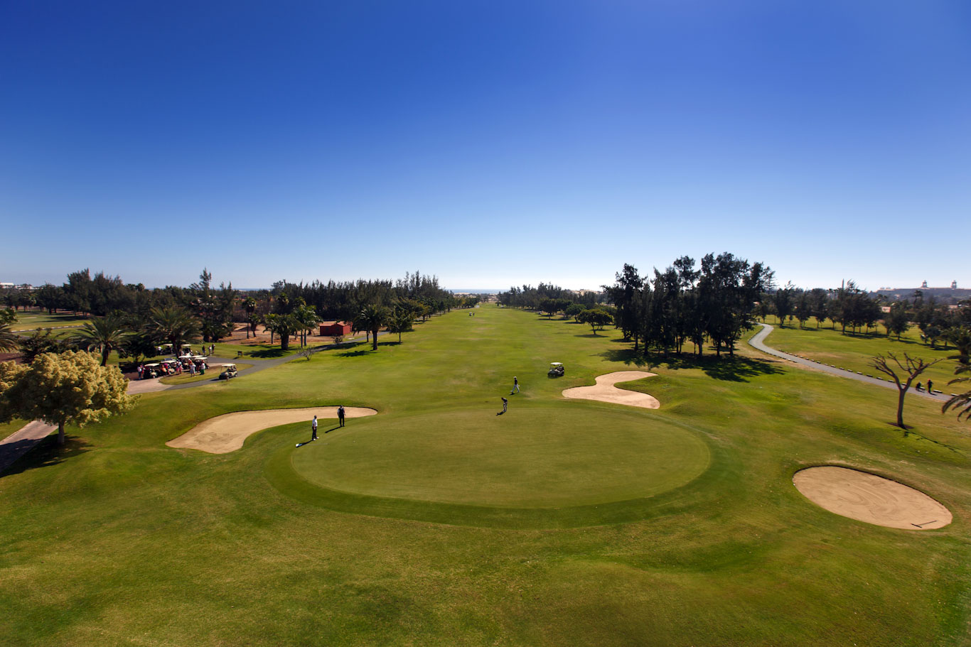 Golfers approaching the green at Maspalomas Golf Club, Gran Canaria, Canary Islands